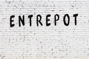 Beyaz tuğla duvara siyah boya ile yazılmış bir yazıt..