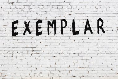 Beyaz tuğla duvara siyah boya ile yazılmış bir yazı örneği..