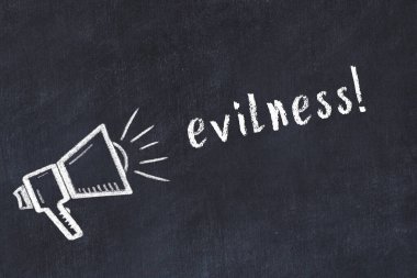 Hoparlörün tebeşir çizimi ve siyah masanın üzerine el yazısıyla yazılmış kötülük.