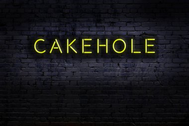 Tuğla duvara yazıIı neon levhası. Gece görünümü