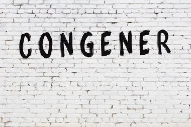 Üzerinde siyah boya bulunan beyaz tuğla bir duvar.