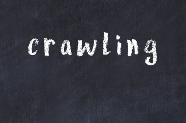 Tebeşir el yazısıyla yazılmış yazı siyah masada sürünüyor.