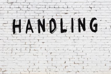 Beyaz tuğlalı duvara siyah boya ile yazılmış yazı sapı.