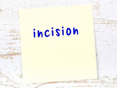 Tahta duvarda el yazısıyla yazılmış kesikli sarı yapışkan bir not var.