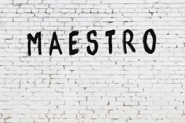 Yazıt üstadı beyaz tuğla duvara siyah boya ile yazılmış..