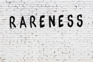 Üzerinde siyah boya bulunan beyaz tuğla bir duvar.