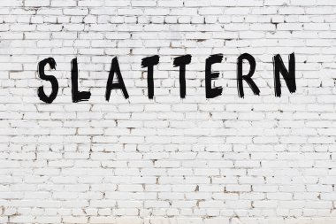 Yazılı beyaz tuğla duvar, siyah boyalı el yazısı.