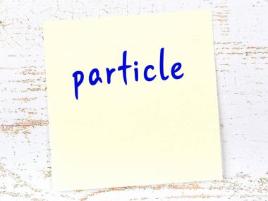 Parçacık hakkında hatırlatma kavramı. Tahta duvarda üzerinde yazı olan sarı yapışkan kağıt.