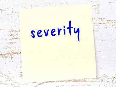 Tahta duvardaki sarı yapışkan notta el yazısı sertliği var.