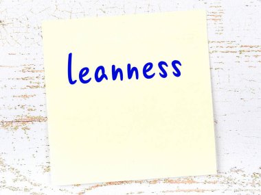 Zayıflığı hatırlatma kavramı. Tahta duvarda üzerinde yazı olan sarı yapışkan kağıt.