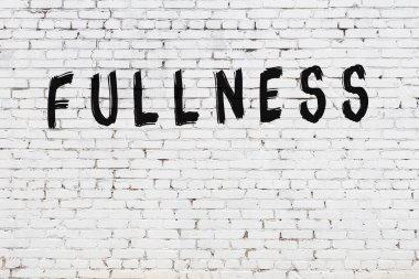 Beyaz tuğla duvara siyah boya ile yazılmış yazım dolgunluğu.