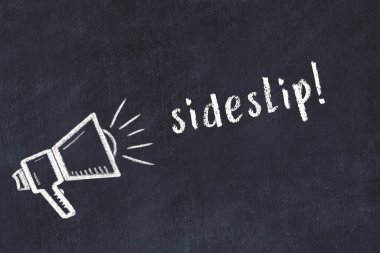 Hoparlörün tebeşir çizimi ve siyah masanın üzerine el yazısıyla yazılmış yazı defteri.