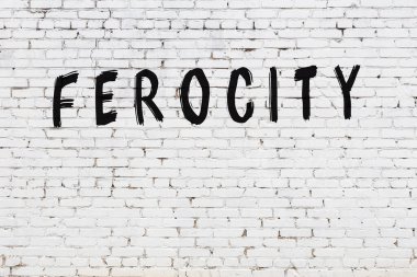 Beyaz tuğla duvara siyah boya ile yazılmış bir yazıt..