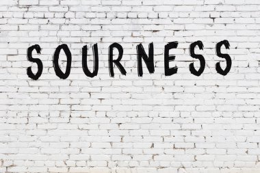 Üzerinde yazı olan beyaz tuğla duvar. Elle yazılmış siyah boya.