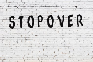 Yazılı beyaz tuğla duvar. Siyah boyayla yazılmış.