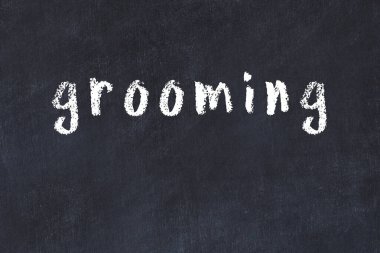 Tebeşir el yazısıyla yazılmış yazı, siyah masanın üzerinde tımar ediliyor.