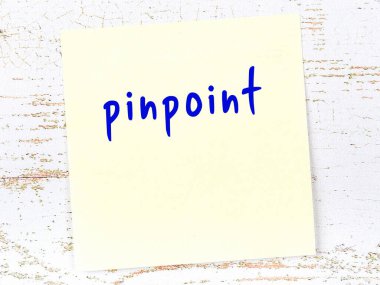 Tahta duvarda el yazısıyla işaretlenmiş sarı yapışkan bir not.