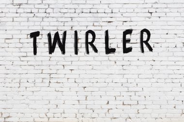 Siyah boyayla el yazısıyla yazılmış beyaz tuğlalı bir duvar.