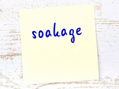 Tahta duvardaki sarı yapışkan notta el yazısıyla ıslatılmış.