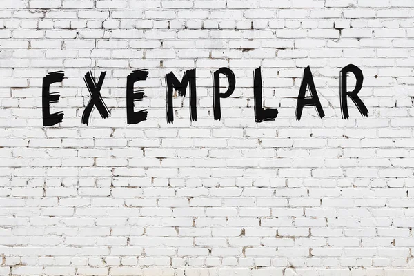 Beyaz tuğla duvara siyah boya ile yazılmış bir yazı örneği..