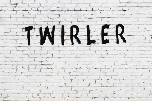 Siyah boyayla el yazısıyla yazılmış beyaz tuğlalı bir duvar.