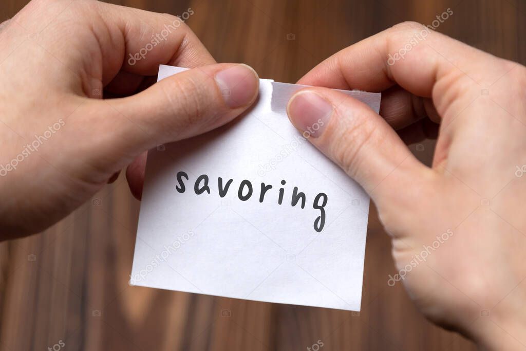 Cancelling savoring. Hands tearing of a paper with handwritten inscription.