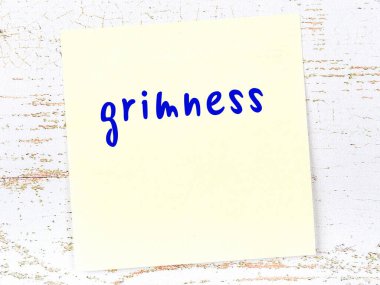 Grimliği hatırlatma kavramı. Tahta duvarda üzerinde yazı olan sarı yapışkan kağıt.