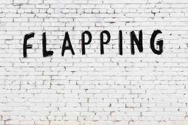 Yazı, beyaz tuğla duvara siyah boya ile yazılmış..