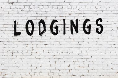 Beyaz tuğla duvara siyah boya ile yazılmış yazıt pansiyonları.