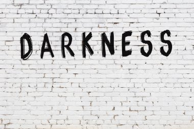 Yazı karanlığı beyaz duvarda siyah boya ile yazılmış..