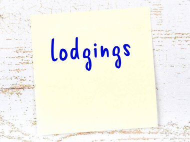 Ahşap duvarda sarı yapışkan bir not ve el yazısıyla yazılmış bir pansiyon.