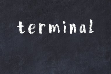 Tebeşir elle yazılmış yazı terminali siyah masanın üzerinde.