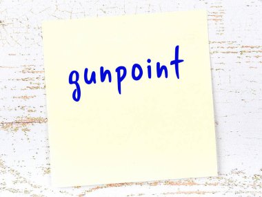 Tahta duvardaki sarı yapışkan notta el yazısıyla yazılmış silah ucu var.