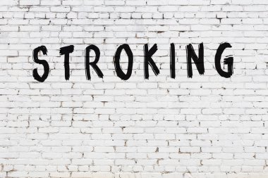 Üzerinde yazı olan beyaz tuğla duvar. Siyah boyayla yazılmış.