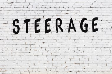 Beyaz tuğla duvarda siyah boyayla yazılan yazıtlar..