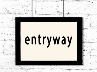 Beyaz tuğla duvarda yazılı girişi olan siyah ahşap çerçeve. 