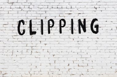 Yazılı beyaz tuğla duvar. Siyah boyayla yazılmış.