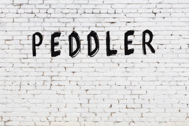 Üzerinde siyah boya bulunan beyaz tuğlalı bir duvar.