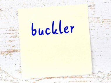 Buckler 'ı hatırlatma kavramı. Tahta duvarda üzerinde yazı olan sarı yapışkan kağıt.