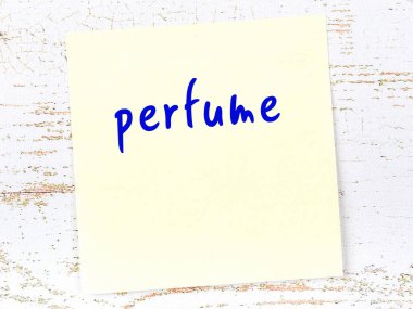 Tahta duvarda el yazısı parfümlü sarı yapışkan bir not.