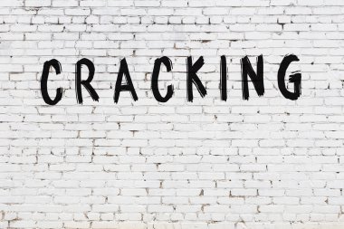 Beyaz tuğla duvara siyah boya ile yazılmış yazıtlar..