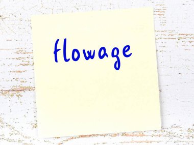 Tahta duvarda el yazısıyla yazılmış sarı yapışkan bir not var.