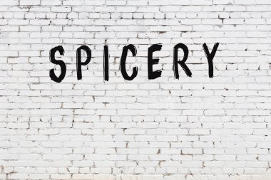 Beyaz tuğladan duvar ve siyah boyayla yazılmış baharat.