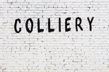 Yazıt kömürü beyaz tuğla duvara siyah boya ile yazılmış..