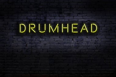 Duvara kazınmış davul başlıklı neon levhası. Gece görünümü