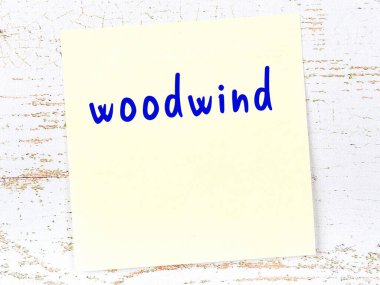 Tahta duvarda sarı yapışkan bir not, el yazısıyla yazılmış ahşap bir rüzgar.