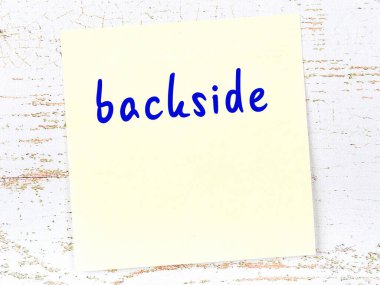 Ahşap duvarda el yazısıyla yazılmış arka tarafında sarı yapışkan bir not var.