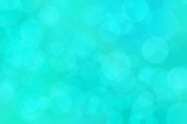 Çember şeklindeki bokeh noktalarıyla mavi ve yeşil soyut odaklanmış arkaplan