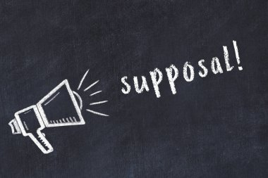 Hoparlörün tebeşir çizimi ve siyah masanın üzerine el yazısıyla yazılmış yazı.