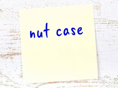 Ahşap duvarda sarı yapışkan bir not ve el yazısıyla yazılmış bir fındık kutusu.